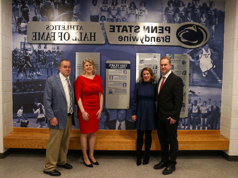 hall of fame inductees standing in front of hall of fame wall