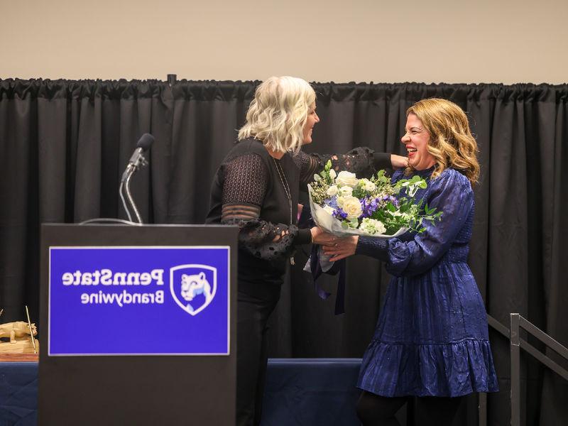 woman receiving flowers on a stage