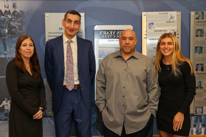 hall of fame inductees standing in front of hall of fame wall